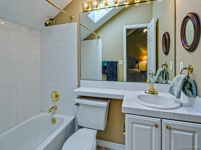 a bed sitting in a room next to a window and a chandelier