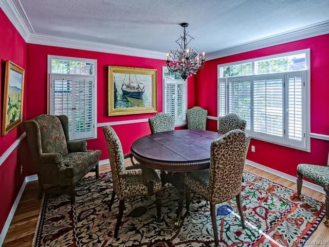a view of a dining room with furniture a chandelier and window