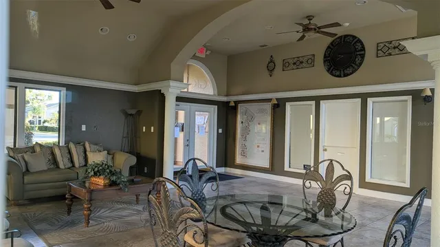 a dining room with furniture and a large window