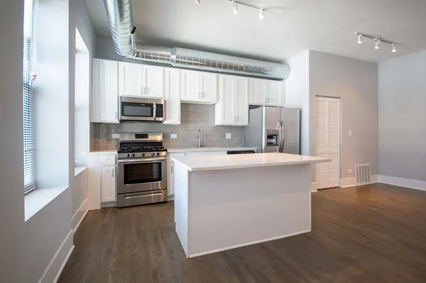 a kitchen with kitchen island a stove a sink and a refrigerator