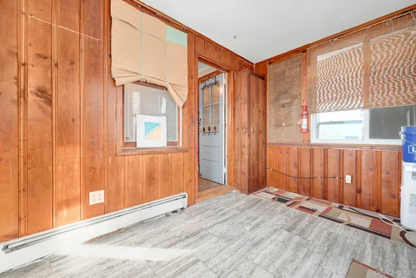 an empty room with a window and wooden floor