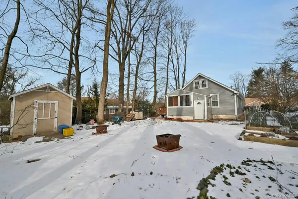 a view of a blue house with snow on the road