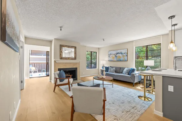 a living room with furniture large window and wooden floor