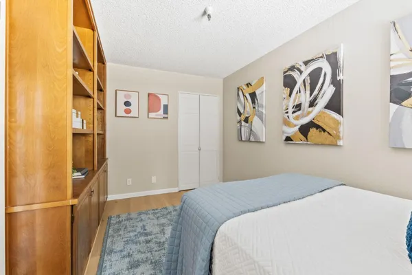 a bedroom with a bed and painting on the wall