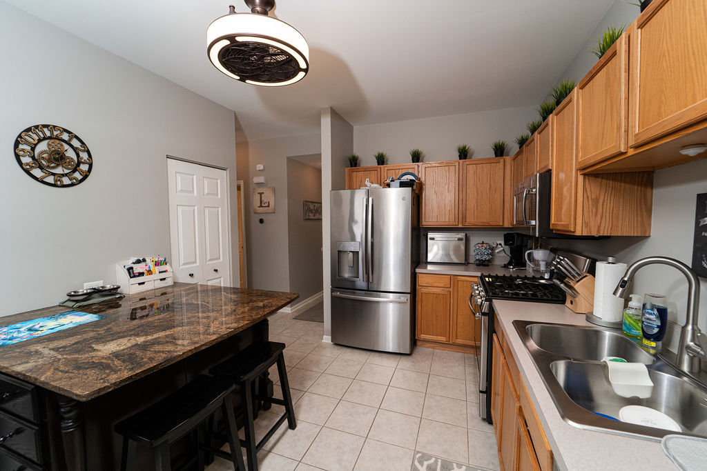 364 Littleton Trail Elgin, IL 60120 - Photo 17 of 36 a kitchen with stainless steel appliances granite countertop a sink refrigerator stove and microwave