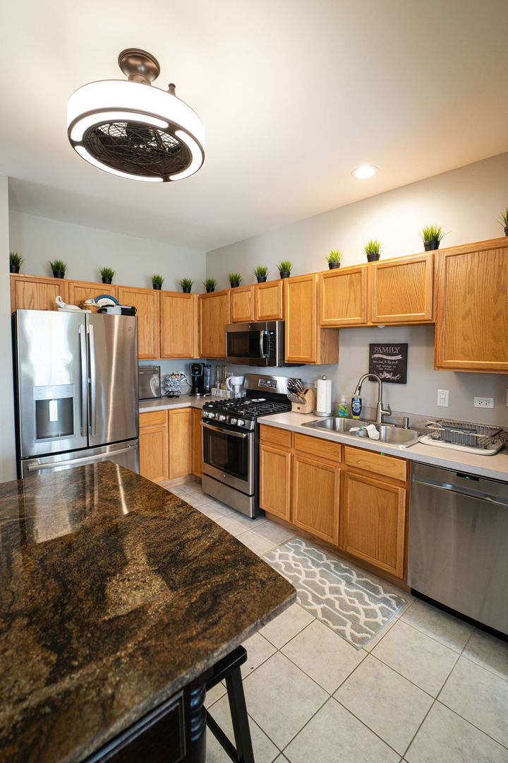 364 Littleton Trail Elgin, IL 60120 - Photo 18 of 36 a kitchen with stainless steel appliances granite countertop a sink and a stove