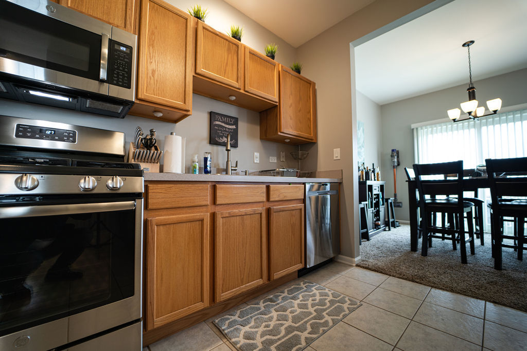 364 Littleton Trail Elgin, IL 60120 - Photo 20 of 36 a kitchen with stainless steel appliances granite countertop a stove a sink and a microwave