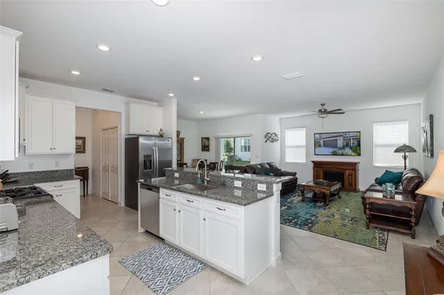 a kitchen with granite countertop a sink a stove and cabinets