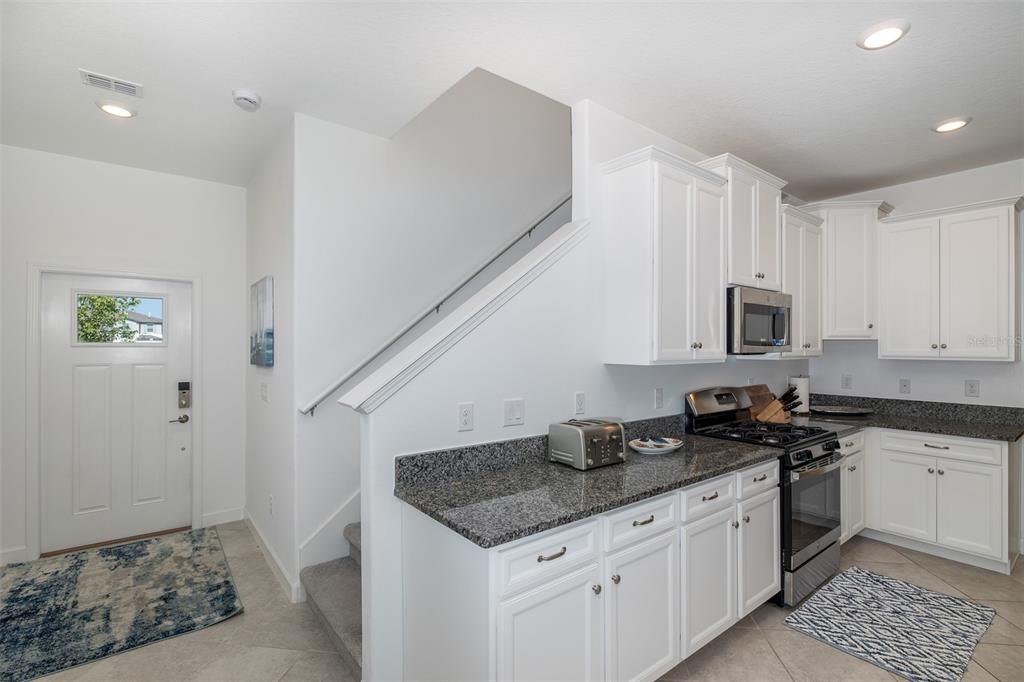 3072 Hover Hall Lane New Port Richey, FL 34655 - Photo 25 of 51 a kitchen with granite countertop a sink a stove and cabinets