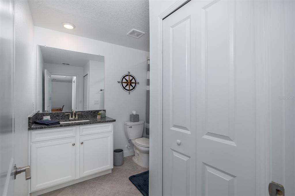 3072 Hover Hall Lane New Port Richey, FL 34655 - Photo 40 of 51 a bathroom with a granite countertop sink a toilet and a mirror