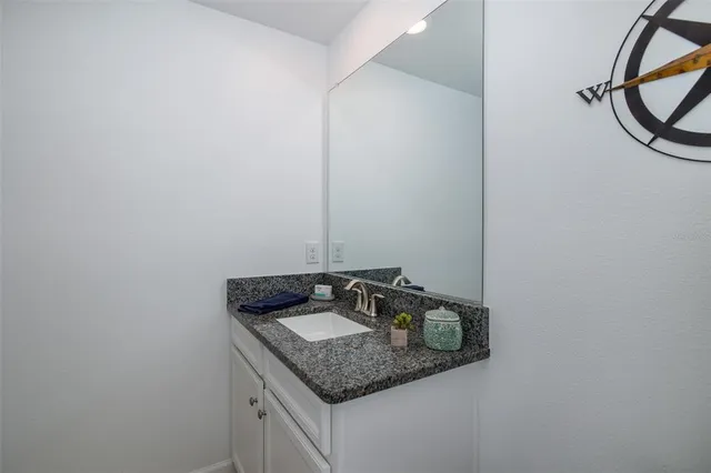 a bathroom with a granite countertop sink and a toilet