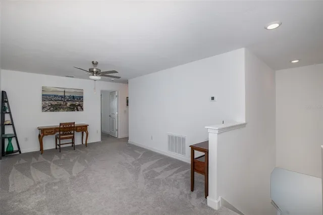 an empty room with fan and windows