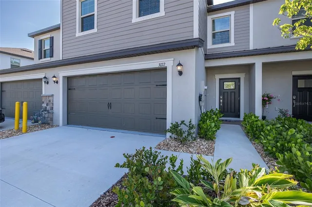 a view of a house with backyard and sitting area