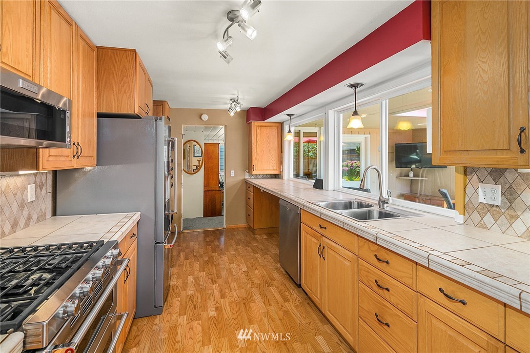 830 Main Street Edmonds, WA 98020 - Photo 9 of 29 a kitchen with granite countertop a sink a counter space appliances and cabinets