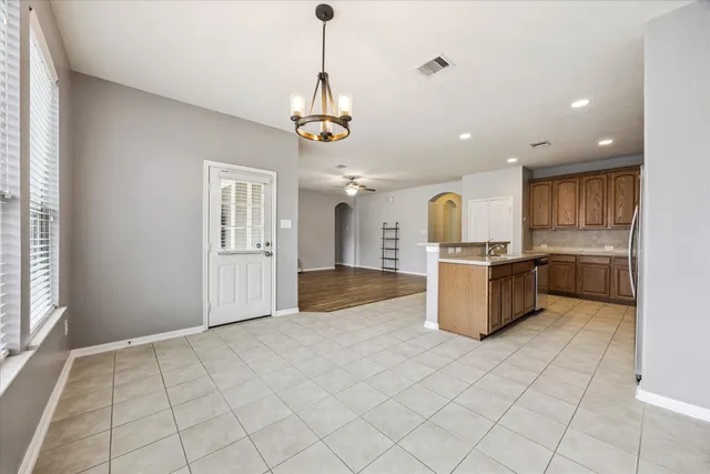 a view of kitchen with granite countertop stove top oven and cabinets
