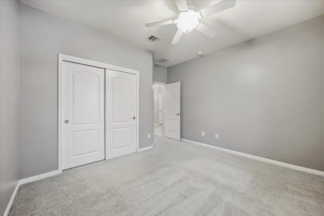 an empty room with a ceiling fan and a fan
