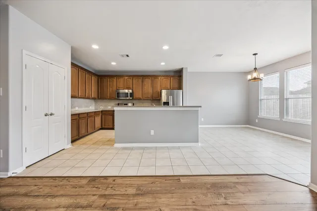a view of kitchen with granite countertop window and a refrigerator