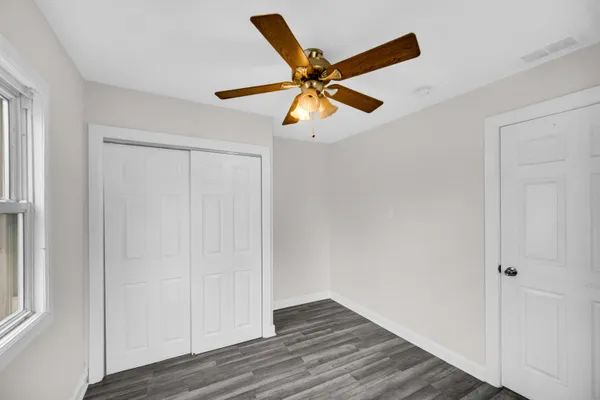 a view of an empty room with closet and a window