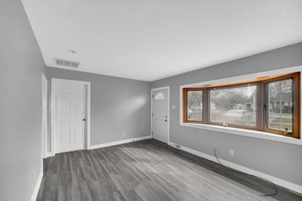 a view of an empty room with wooden floor