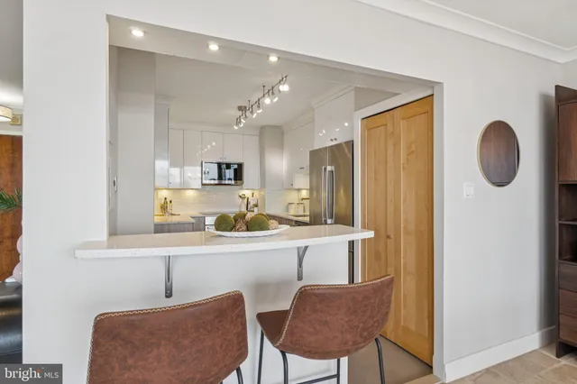 a kitchen with stainless steel appliances granite countertop a sink and a refrigerator