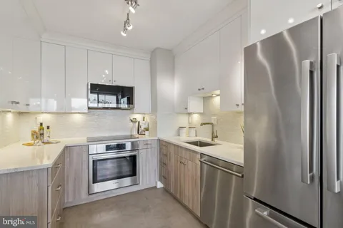 a kitchen with stainless steel appliances a sink stove and refrigerator