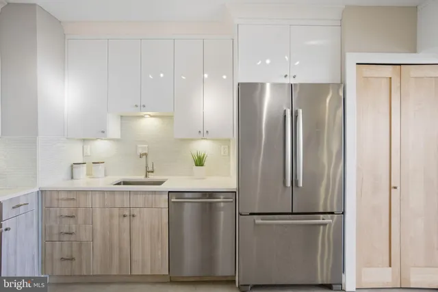 a kitchen with stainless steel appliances granite countertop a refrigerator sink and white cabinets