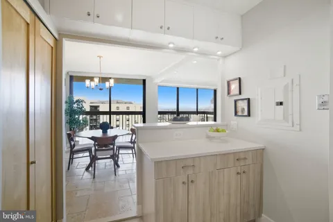 a view of kitchen with kitchen island dining table and chairs