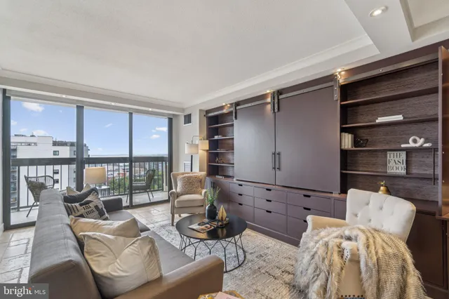 a living room with furniture and a floor to ceiling window