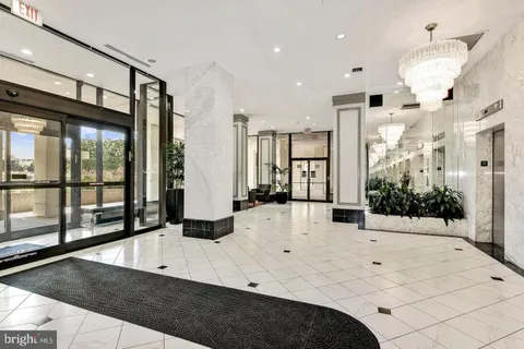a large white kitchen with a large window and stainless steel appliances