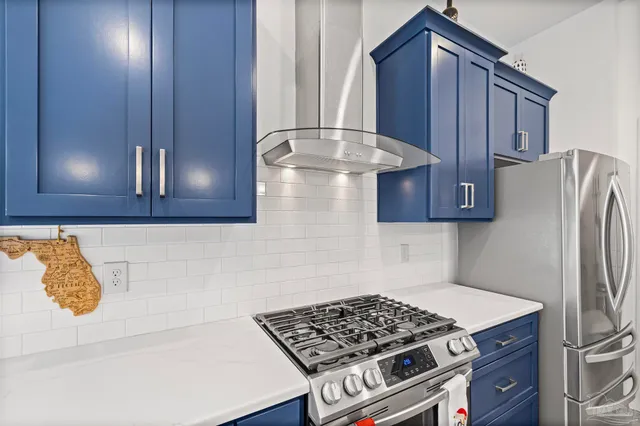 a kitchen with a refrigerator and a stove top oven