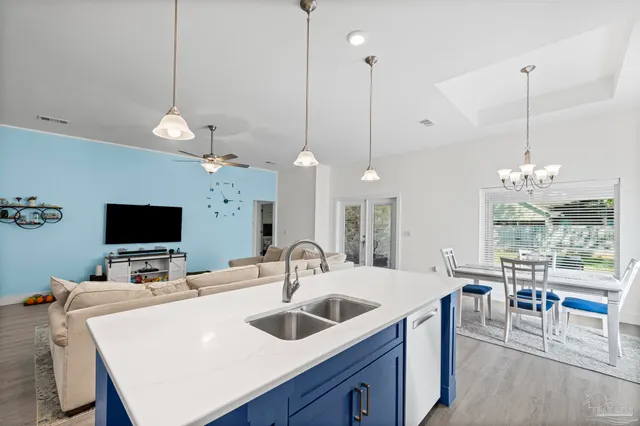 a dining room with furniture a chandelier and wooden floor