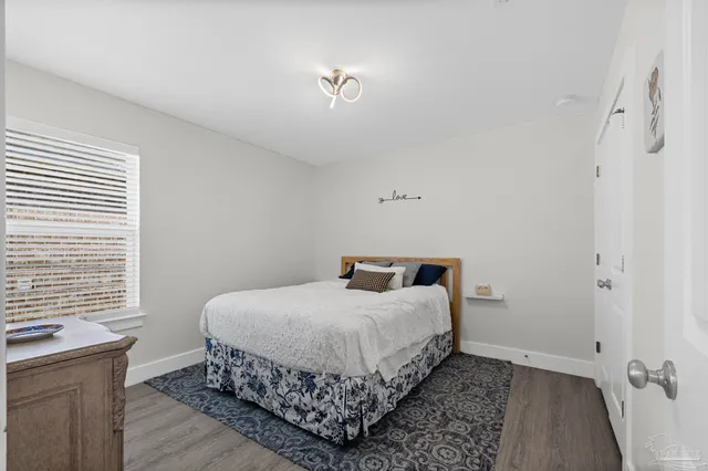 a bedroom with a bed and a flat tv screen on wall