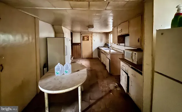 a kitchen with refrigerator and chairs