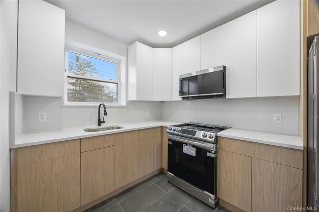 a kitchen with a refrigerator sink and wooden cabinets