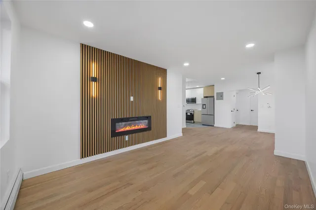 a view of a kitchen with white cabinets and wooden floor