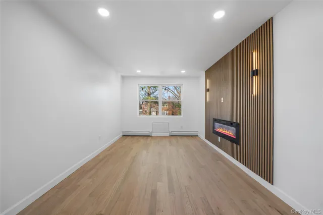 a view of a big room with wooden floor and windows