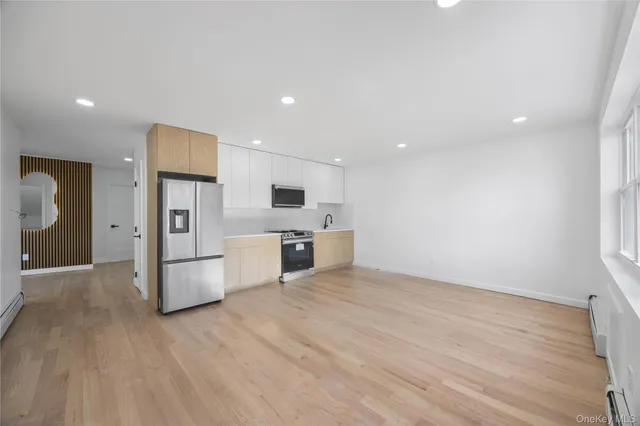 a large kitchen with stainless steel appliances granite countertop a stove a sink and a refrigerator