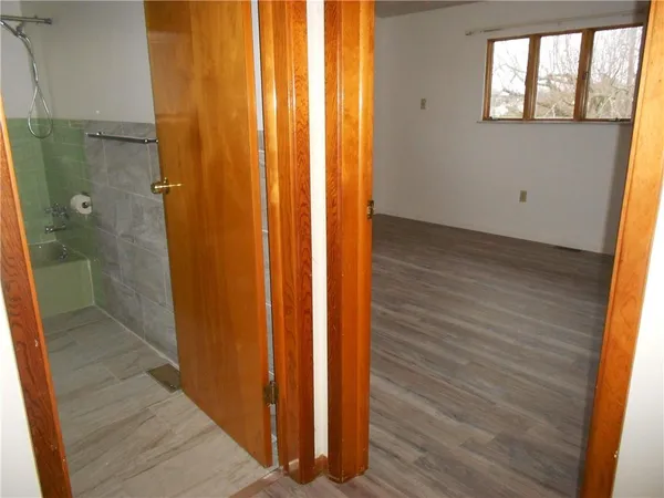 wooden floor in an empty room with a bathroom