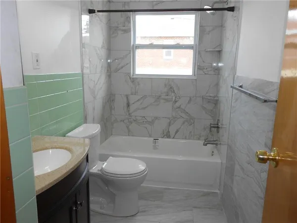 a bathroom with a granite countertop toilet sink and shower