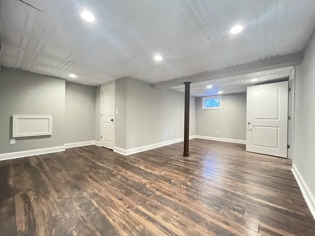 a view of an empty room with wooden floor and closet