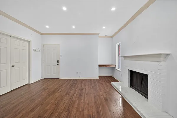 a view of empty room with wooden floor and fireplace