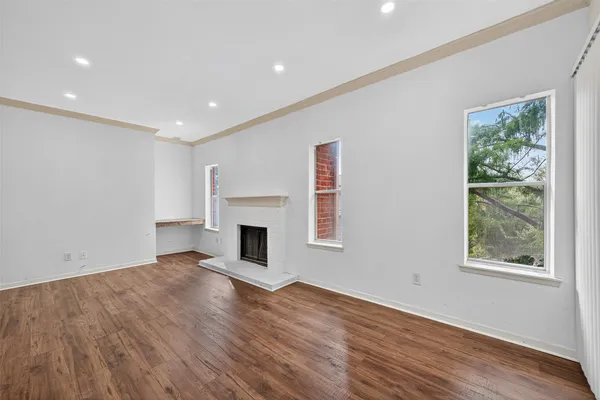 a view of empty room with wooden floor and fireplace