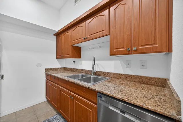 a kitchen with granite countertop a sink and cabinets