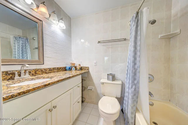 a bathroom with a granite countertop toilet sink and a mirror