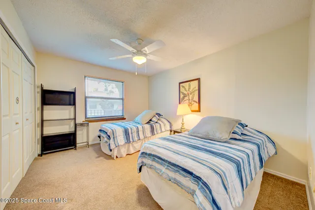a bedroom with two beds and painting on the wall