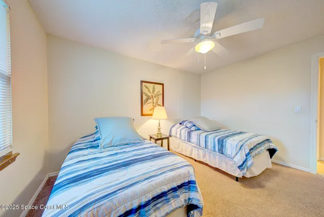a bedroom with two beds and a chandelier
