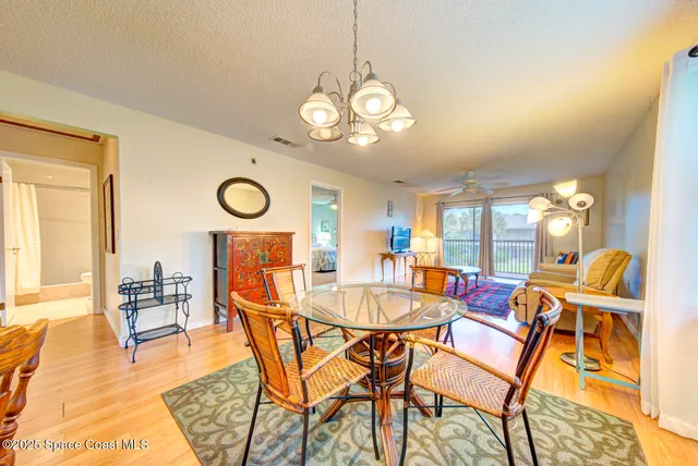 a dining room with wooden floor and a chandelier