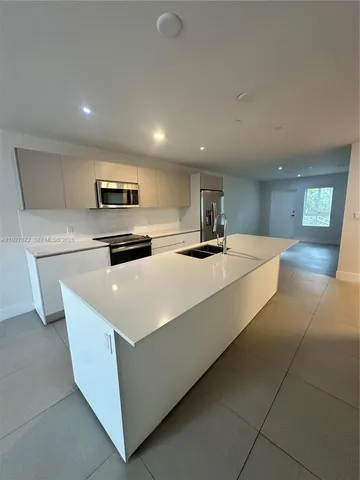a large kitchen with a large counter top appliances and cabinets
