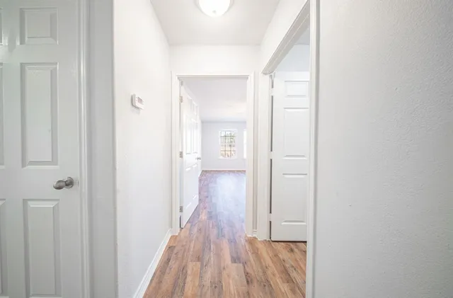 a view of a hallway with wooden floor