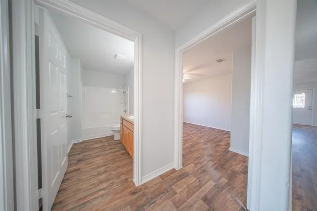 a view of a hallway with wooden floor